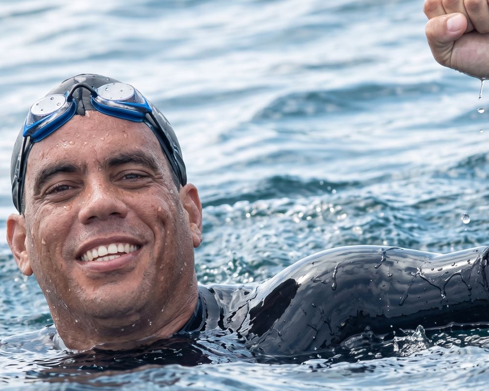 Antonio Saint Aubyn, nadador cumanés, celebrando victorioso en el mar durante un reto de natación de aguas abiertas en Venezuela.