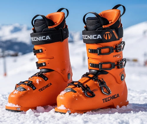 Botas de esquí de alto rendimiento Tecnica Mach 1 color naranja sobre la nieve
